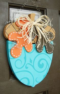 a door hanger decorated with an orange and brown fish on it's side