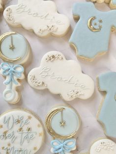 decorated cookies with blue and white icing are arranged on a tablecloth that says welcome you to the world