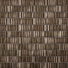 a close up view of a brown glass mosaic tile wall with vertical strips on it