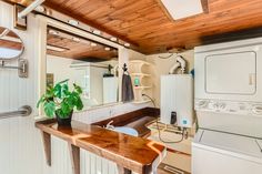 a washer and dryer in a room with wood ceilinging on the walls