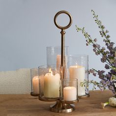 some candles are sitting on a table with flowers