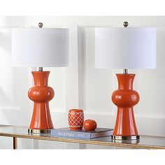 two orange lamps sitting on top of a table