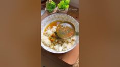 a bowl filled with rice and sauce on top of a table