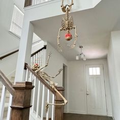 a skeleton hanging from the ceiling next to a stair case with a light bulb in it