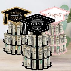 a graduation cap and diploma on top of stacks of money in front of a sign that says congratulations