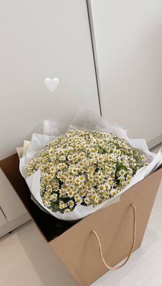 a bouquet of daisies in a brown paper bag