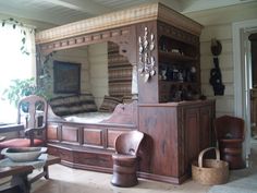 a bedroom with a bed, chair and bookshelf in the middle of it