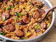 sausage and rice in a pan with a wooden spoon