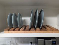 plates are stacked on a wooden board in the kitchen