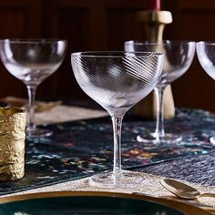 there are four wine glasses on the table ready to be set for dinner party guests