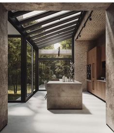 an indoor kitchen with large windows and concrete counter tops