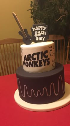 a three tiered cake decorated with an arctic monkey and happy 16th birthday sign on top