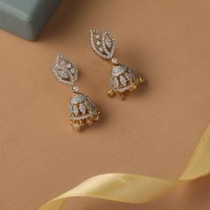 Description : Leafy CZ Jhumki Earrings reflect the sheen and shape of the mini jhumki motif suspended from a leaf stud motif studded with CZ stone. Wear these intricately handcrafted silver Jhumki on their own or with classic jewelry for exquisite styling. Details & Specification : Materials used: Brass Alloy with White Rhodium / Gold & White Gold Platting Weight - 8.10gm Length - 3cm Make it custom : Want to make it a custom Earrings? Sure! Reach out to us at support@tarinika.com and we’ll be h Small Butta Earrings Gold, White Stone Earrings Indian Gold, Buy Jewellery Online, Jhumki Earrings, Indian Jewellery Design, Traditional Earrings, Jewellery Inspiration, Kundan Earrings, Indian Earrings