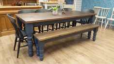 a kitchen table with two benches in front of it and several chairs around the table