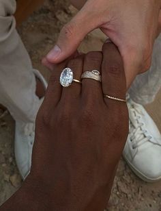 a man and woman holding each other's hand with their wedding rings on them