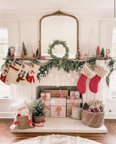 christmas stockings hanging from the mantle in front of a mantel with presents under it