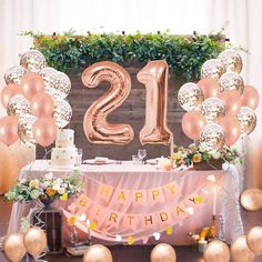 a 21st birthday party with balloons, cake and flowers on the table in front of it