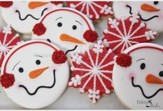 snowmen decorated cookies with red and white frosting on them are sitting next to each other