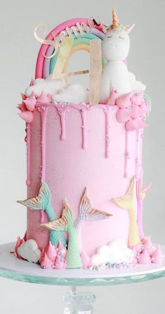 there is a pink cake with unicorns on it