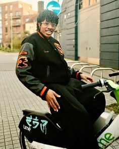 a man sitting on top of a motor scooter in front of a building