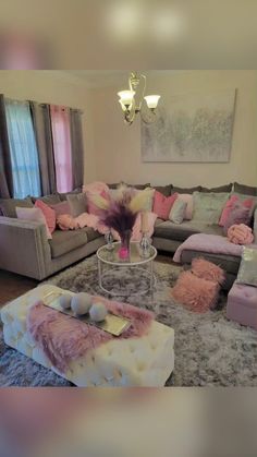 a living room filled with lots of furniture next to a chandelier hanging from the ceiling