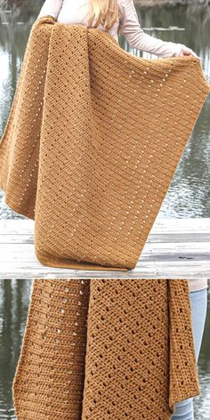 a woman is holding a large brown crocheted blanket over her head and standing on a dock