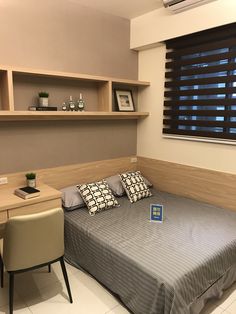 a bedroom with a bed, desk and shelves on the wall next to it's headboard