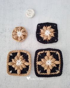 four crocheted squares with flowers on them sitting on top of a white surface