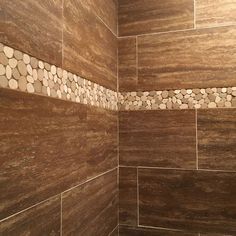 there is a shower with rocks on the wall