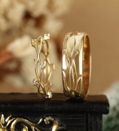 two gold wedding rings sitting on top of a table