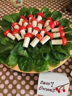 a plate with toothpicks on top of spinach leaves and cherry tomatoes in the middle