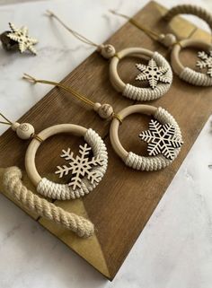 three wooden hoops with snowflakes on them are sitting on a wood board