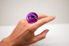 The Loop Ring is a one-banded contemporary acrylic design inspired by its symbolism of love, connection and binding. It also symbolizes good luck, protection and liberation. Each piece is unique and handcrafted allowing for the wearer to style themselves with contemporary wearable design. 100% Acrylic | Handcrafted | Made in Miami Modern Purple Ring For Gift, Modern Purple Rings For Gift, Wearables Design, Acrylic Design, Acrylic Ring, Contemporary Ring, Acrylic Designs, Knot Ring, Art Contemporary