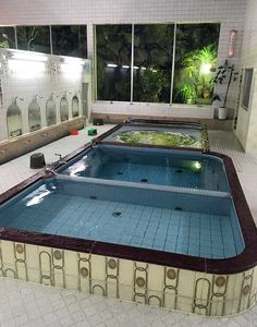 an indoor swimming pool in a building with tiled flooring and walls that look like they have been built into the ground