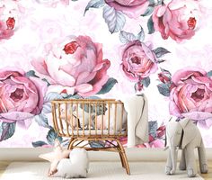 a baby's room with pink flowers on the wall and a crib next to it