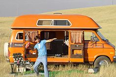 a man standing in front of an orange van