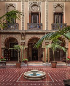 an ornate courtyard with potted plants and palm trees