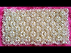 white pearls are arranged in rows on a pink background