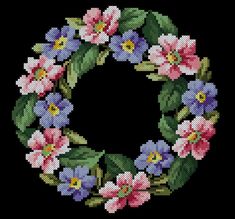 a cross stitch wreath with pink and purple flowers