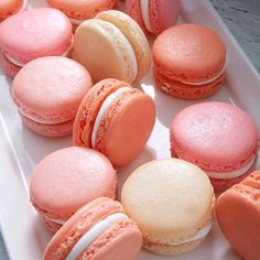 there are many pink and white macaroons on the plate