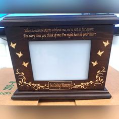 a wooden frame with a poem written in gold on the side and butterflies around it