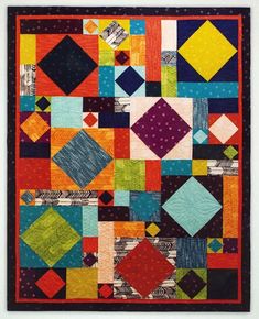 a colorful quilt is hanging on the wall