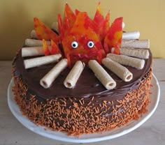 a cake decorated with cinnamon sticks and an orange fire hydrant sitting on top of it