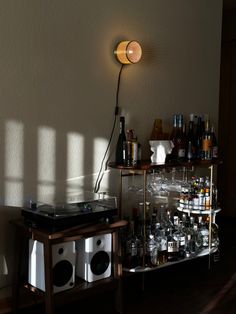 a record player sitting on top of a table next to a shelf filled with bottles