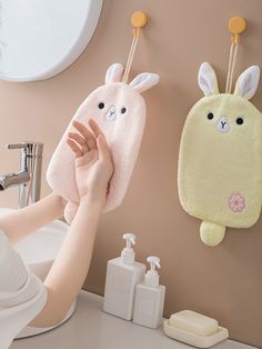 two bunny shaped towels hanging on the wall