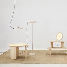 three wooden tables and two lamps on the floor