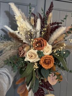 a vase filled with flowers and feathers on top of a table