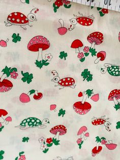 the fabric has mushrooms and ladybugs on it