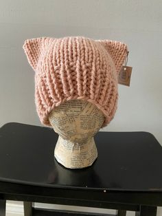 a knitted cat hat sitting on top of a wooden table