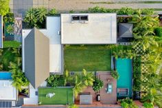 an aerial view of a house and pool surrounded by palm trees